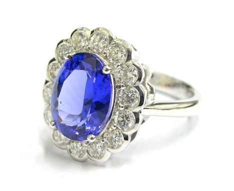 A tanzanite and diamond dress ring, set with oval tanzanite stone, surrounded by round brilliant cut stones, the tanzanite to