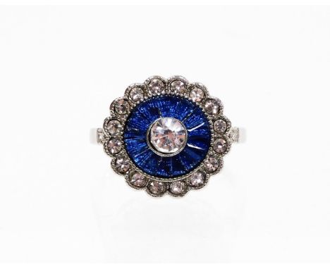 An Art Deco style modern target ring, set with blue and white paste stones, on modern costume band, ring size X. 