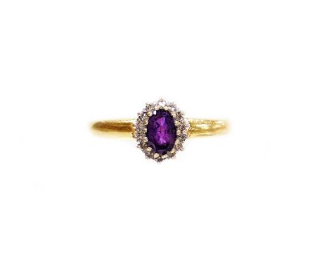 An 18ct gold cluster ring, the centre set with oval cut amethyst surrounded by tiny diamonds, in a raised claw platinum setti