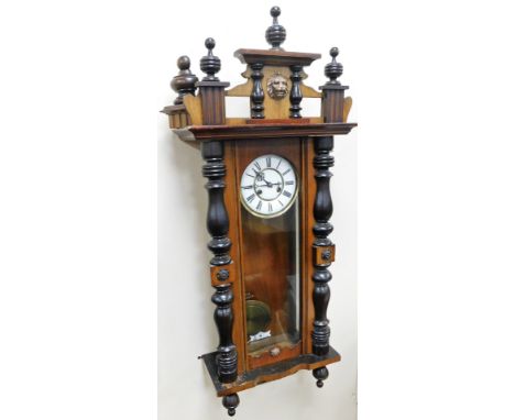 An early 19thC walnut Vienna wall clock, the cornice with pillars and lion mask, with a white enamel Roman numeric dial, with