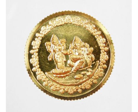 A Tanishq gold coin, depicting two Hindu figures, stamped 995 fine gold, 10g, in presentation sleeve and certificate of authe