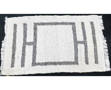 A large wool rug, with cream overall design and grey central decoration, on light tassel thread ends, 277cm x 165cm. 