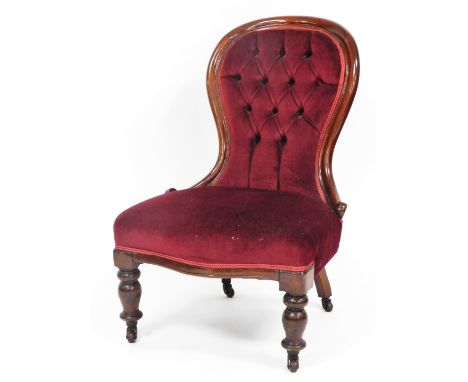 A Victorian button back nursing chair, the mahogany frame with red button velvet seat, on turned legs terminating in castors,