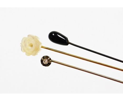 Three stick pins, comprising an old cut diamond set stick pin, on steel pin, a mother of pearl rose type topped stick pin and