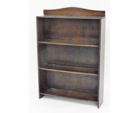 An oak bookcase, with three shelves and a curved cornice with bobbin separation, on plain block legs, 116cm high, 67cm wide, 