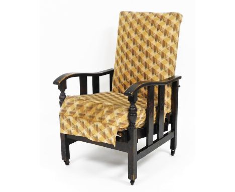 An early 20thC rocking chair, with bobbin turned shaped arms, with two splats and carved decoration, on a reclining seat, ter
