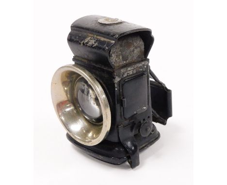 A 20thC bicycle lamp, with single glass front, and shield for Lucas depicting a lion carrying a flaming torch, 12cm high.