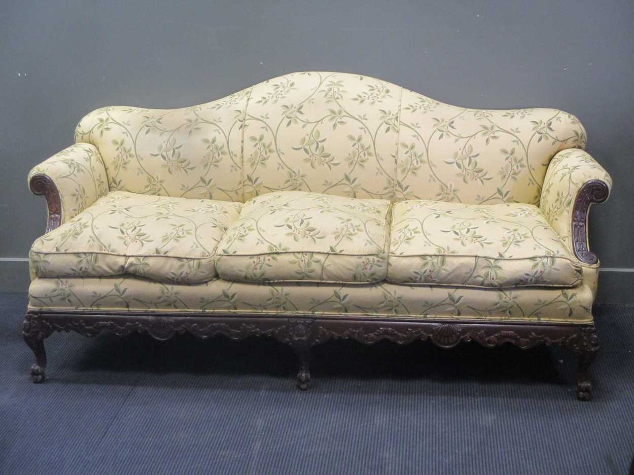 A carved frame camel back sofa, early 20th century, re-upholstered, c ...