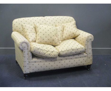 An Edwardian drop end two seat sofa, re-upholstered