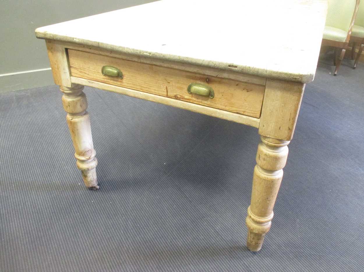 A pine farmhouse kitchen table with two end drawers, on turned legs 78