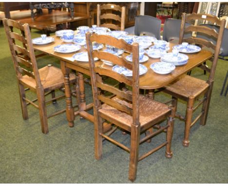An oak gate leg drop leaf table plus six oak ladder back rush seated dining chairs 