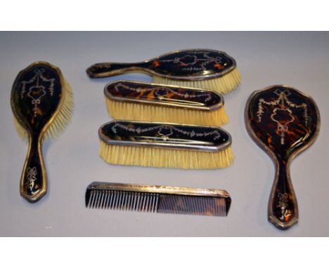 A tortoise-shell and silver bound suite of dressing-table items, including brushes, hand mirror and a comb