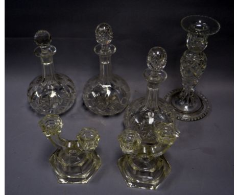 A set of three cut-glass decanters (one stopper non-matching), a pair of glass candlestick, and a further candlestick