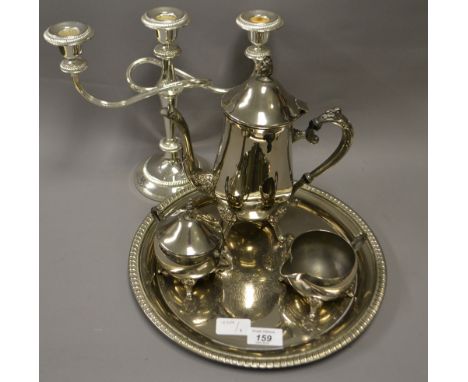 A three piece silver plated tea service, circular tray and a candelabra 