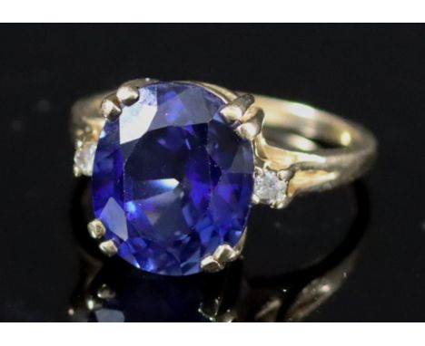 A Sapphire and Diamond Ring, Modern, in 14ct gold mount, set with a central oval sapphire, approximate weight 4ct, flanked by