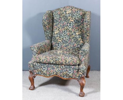 An Early 20th Century Wingback Easy Chair of "18th Century" Design, upholstered in tapestry, on leaf capped cabriole legs wit