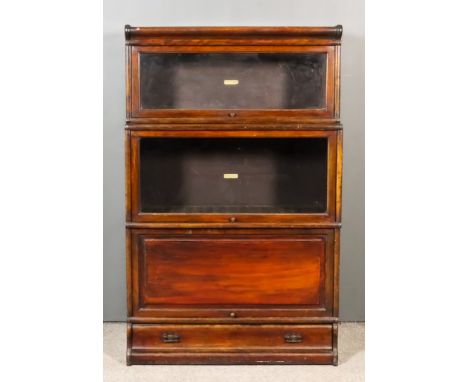 A 1920's Globe Wernicke Stained Wood Three-Tier Sectional Bookcase, two tiers with glazed rising fronts, one tier with panell