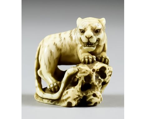 A Japanese Carved Ivory Netsuke of a Tiger by Masatomo, 19th Century (Edo Period), the snarling beast standing on rock work, 