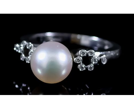 A Pearl and Diamond Ring, Modern, in 18ct white gold mount, set with cultured pearl, 8mm diameter, flanked by small diamonds,