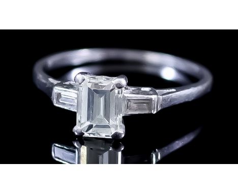 A Three Stone Diamond Ring, Modern, in platinum mount, the centre set with an emerald cut diamond, approximate weight 1.2ct, 