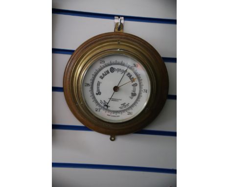 Ships Barometer of Brass on wood base. John Barker &amp; Co Kensington.  11 inches diameter. See photos. 