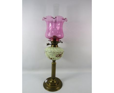 Vintage brass oil lamp with uranium glass reserve and cranberry glass shade, 27" tall to top of chimney.