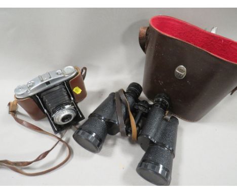 A pair of vintage binoculars plus a camera 