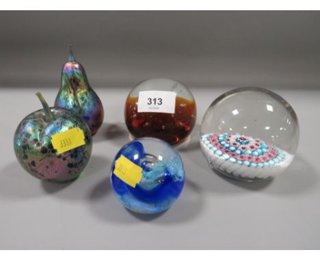 A small selection of paperweights to include two 'Isle of Wight Glass' examples - an apple and a pear, plus two Caithness and
