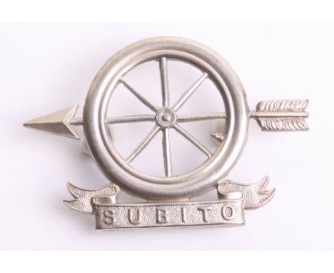British Motor Service Volunteer Corps Cap Badge, white metal 8 spoke tyre with an arrow through the centre. Below is a scroll