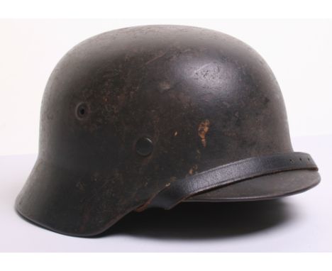 German Army M-40 Pattern Steel Combat Helmet which retains much of the original field paint finish. Non decaled example.  Com