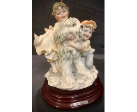 An Italian B Merli of Florence table lamp, the moulded resin base with two children and a dog, 56cm high over shade, stepped 