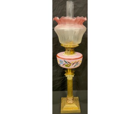A late Victorian oil lamp, brass Corinthian column base, ceramic reservoir, twin burner, acid etched cranberry flashed shade,