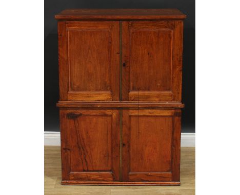 A 19th century campaign-type cabinet on cabinet, oversailing top with moulded edge above a pair of panel doors enclosing a sh