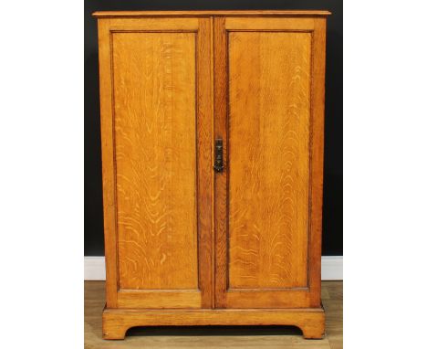 An oak hall robe, of small and neat proportions, rectangular top above a pair of panel doors, bracket-form skirted base, 132.