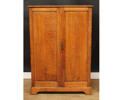 An oak hall robe, of small and neat proportions, rectangular top above a pair of raised and fielded panel doors, bracket-form