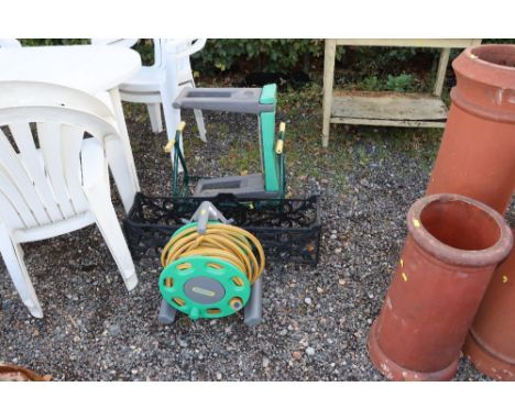 A garden hose and reel, a planter and two garden kneelers