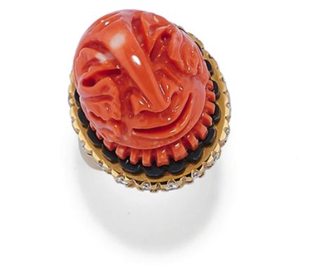 la partie supèrieure avec un bouton de corail sculptè reprèsentant un masque oriental avec une bordure d'onyx et des diamants