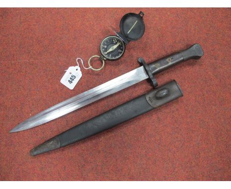 An 1888 Lee Metford Bayonet, with various markings on ricasso and leather scabbard, plus metal field compass.