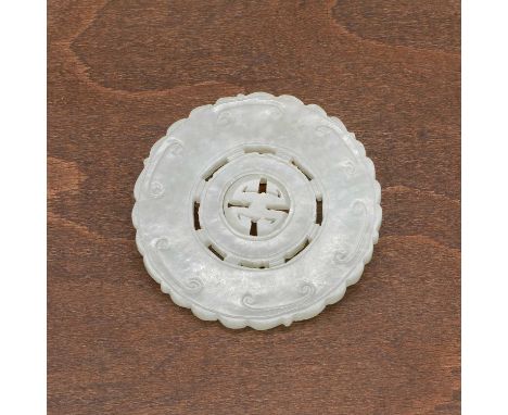 A Chinese jade pendant, Qing dynasty (1644-1911), of shaped circular form, pierced and carved with a shou character in the ce