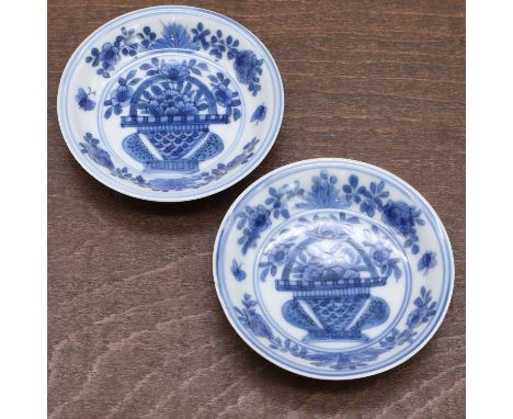 A pair of Chinese blue and white saucers, Wanli (1573-1620), each with rounded sides rising from a circular foot to a slightl