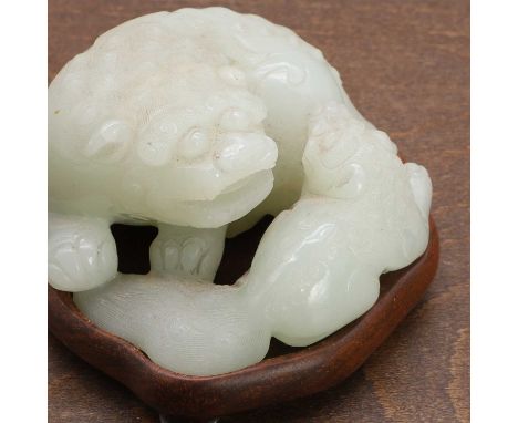 A Chinese jade carving, early Qing dynasty, of a Buddhist lion playing with a pup, the stone of a greyish-white tone,7cm long