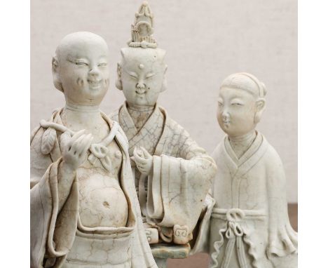 Three Chinese Hutian ware figures, Yuan dynasty (1271-1368), comprising:a Daoist immortal, seated on a raised plinth, wearing