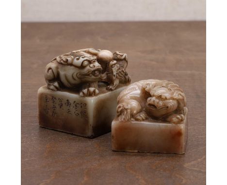 Two Chinese soapstone seals, 20th century, each finial carved with a Buddhist lion, inscribed to the side and seal face,4.3 a