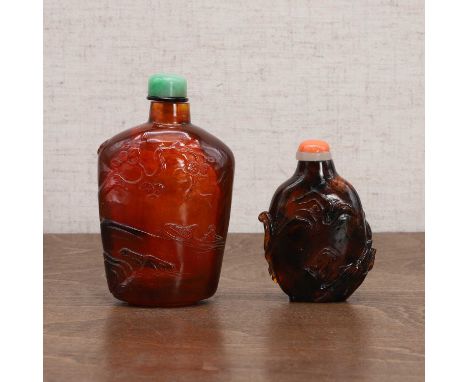 Two Chinese amber snuff bottles, early 20th century, comprising:one carved with literati in a landscape, the stopper with a j