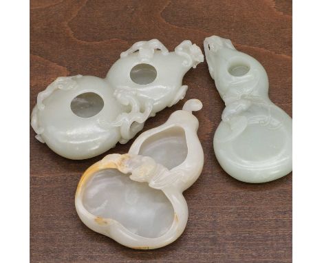 Three Chinese jade carvings, 20th century, each in the form of a double gourd, carved with a bat or chilong,11.5 to 12.5cm lo