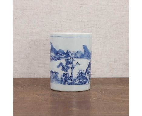 A Chinese blue and white brush pot, Kangxi (1662-1722), of cylindrical form, painted with a landscape in a rectangular panel,