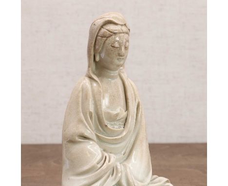 A Chinese porcelain guanyin, Republic period (1912-1949), seated wearing a loose robe exposing his chest, covered with a crac