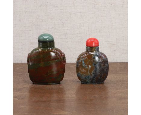 Two Chinese jasper snuff bottles, Qing dynasty (1644-1911), plain, one with mask and ring handles, the stopper with a glass c