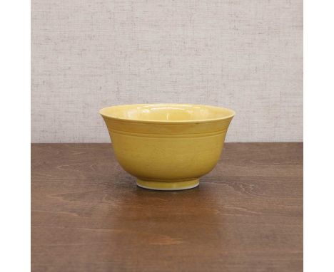 A Chinese yellow-glazed bowl, Guangxu (1875-1908), the rounded sides rising from a circular foot to a flared rim, incised wit
