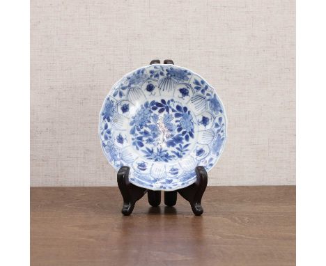 A Chinese blue and white saucer, Kangxi (1662-1722), of lobed form, painted with peony within lotus petal-shaped panels, 11cm